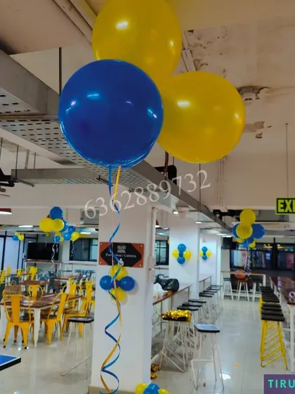 Simple and effective office decoration using large helium balloons and smaller clusters in company brand colors.