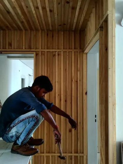 A craftsman at work on the vertical wood paneling for the Gurgaon residence. This photo celebrates the skill and manual labor involved in executing our custom designs, highlighting the human element in our architectural process.