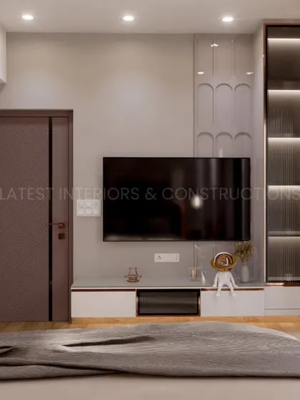 The TV unit in this nature-inspired bedroom is minimalist and functional, with a mix of white and wood finishes. A circular wooden art piece on the wall complements the room's organic theme.