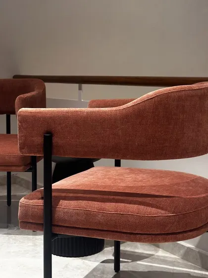 A closer look at the rustic orange statement chair. The curved back and plush seat are designed for comfort, making it an ideal accent chair for a residence or a boutique hotel lobby.