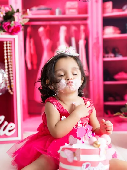 A sweet, cake-covered kiss for the camera! These messy, adorable moments are the heart of a fun and successful first birthday photoshoot.