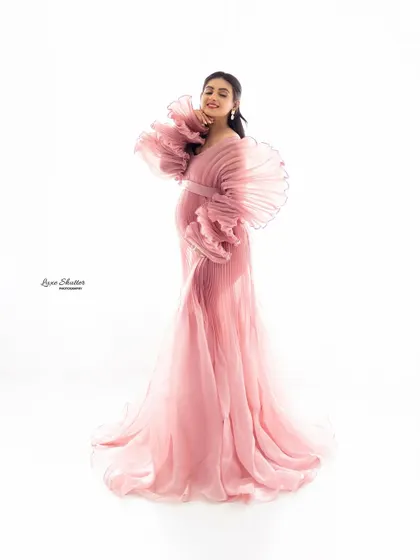 A custom-designed pink pleated gown with incredible ruffled sleeves. This is a true couture maternity look, soft, elegant, and unique.