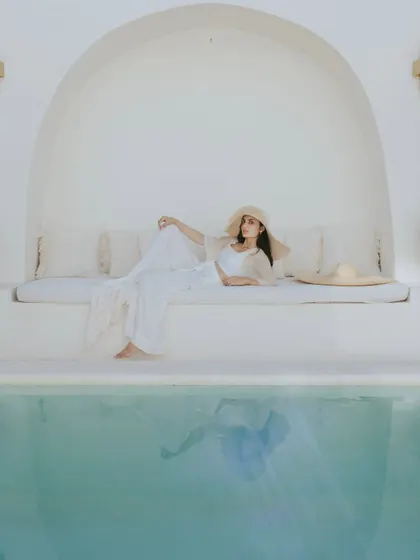 A serene and elegant portrait taken by a poolside in a Bali villa. The reflection of her flowing white dress in the turquoise water adds a touch of magic to this beautifully composed, tranquil moment.