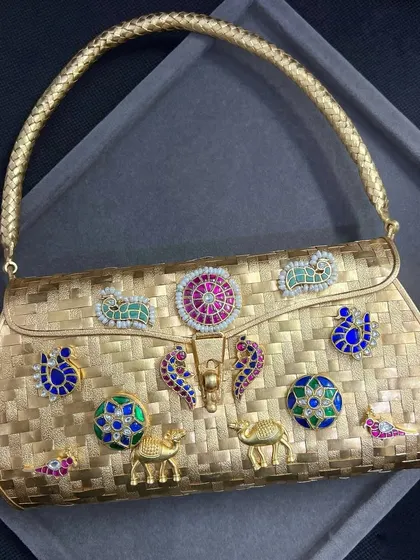 Our gold-plated silver fusion clutch, shown with its woven gold-plated handle attached. This versatile piece can be carried as a clutch or a handbag, matching perfectly with both Indian and Western outfits.