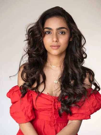 The full, bouncy curls and fresh makeup create a look that is both youthful and glamorous.