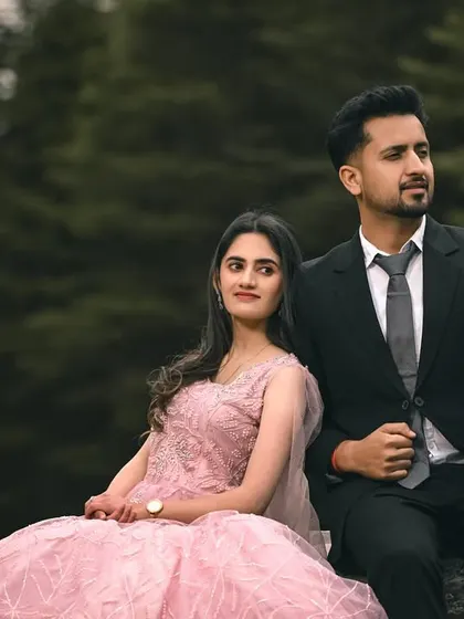 A formal portrait of the couple seated on a rock, looking poised and elegant in the middle of the wilderness.