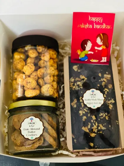This hamper focuses on my healthier options, perfect for the health-conscious recipient. It features a whole wheat jaggery chocolate cake, a jar of date and almond butter cookies, and a jar of dry fruit trail mix.