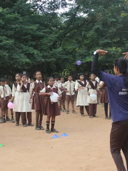 A coach from Pro Sport Development leads a fun activity with balloons for school children in Bhubaneswar to celebrate Children's Day.