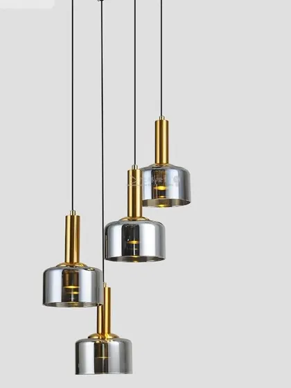 A set of four pendants with smoked glass shades and brass fittings. This is a classic configuration for lighting a kitchen island or dining table.
