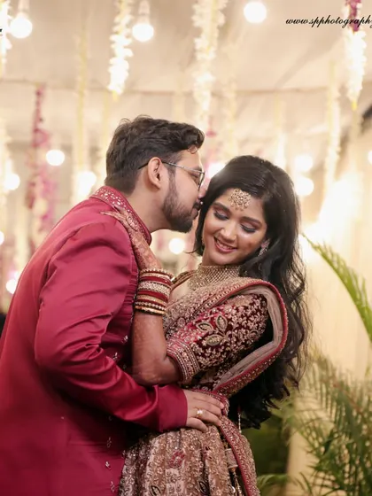 A romantic and intimate portrait from a reception. The groom's gentle kiss and the bride's happy smile create a heartwarming and beautiful image.