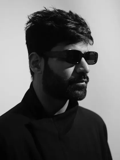 A simple, direct black and white headshot. The focus is on the artist and the music.