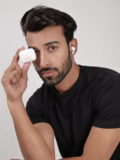 A model holding a white earbud case, with one earbud in his ear. This shot clearly displays the product and its charging case in a relatable human context.