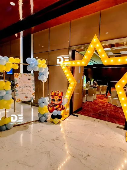 The grand entrance to Keev's party, featuring a giant light-up star and a honeybee balloon sculpture.