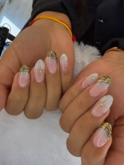 A simple yet elegant design. This set features a sheer base with a soft white ombre, accented with delicate gold wire-like details at the cuticle.