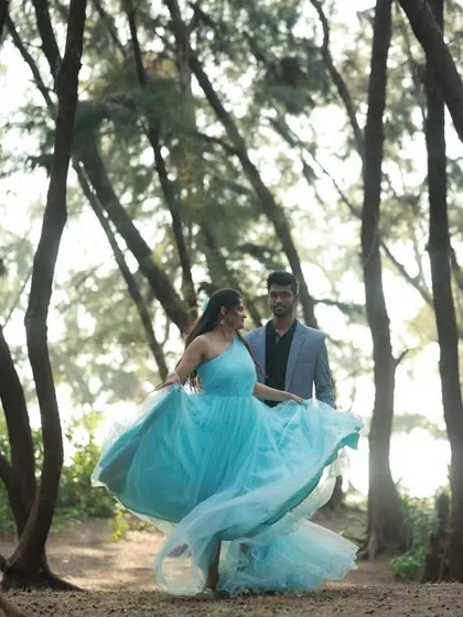 This sky-blue fairy gown is a dreamy choice for a pre-wedding shoot in a forest setting, complemented by a grey suit for him.