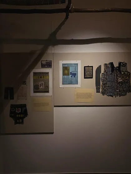 An archival board illuminated by a single light source in the dark gallery.