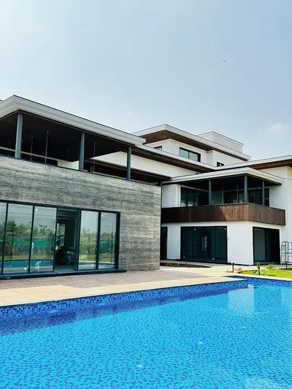 A wide view of the pool in relation to the contemporary architecture of the house, ensuring the design is cohesive.
