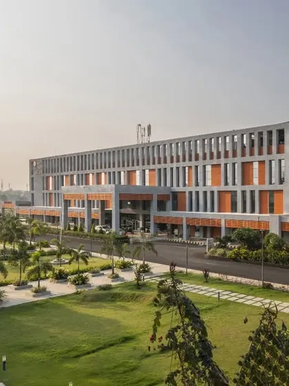 An exterior view of the Cancer Care Centre in Ranchi, showcasing its modern architectural language and integration with the surrounding landscape. The design is based on a universal grid that allows for phased expansion as community needs grow.