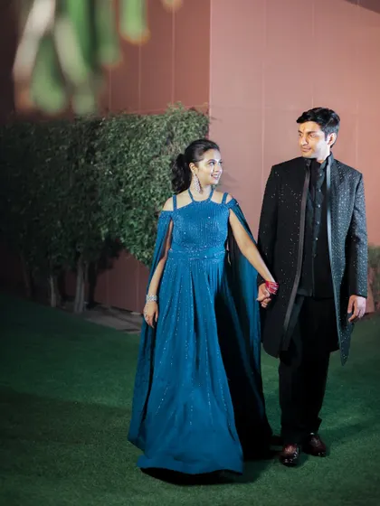 Avichal and Somya share a walk during their engagement shoot at the Taj Hotel in Agra. The bride's flowing blue gown and the groom's classic black attire create a striking contrast.