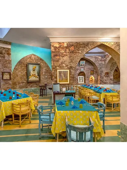 Another angle of the restaurant, showing the interplay of historic architecture and vibrant decor. The artwork and furniture tell the story of the place.