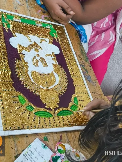 Another angle of a Tanjore painting in progress, showing how the gold work creates a stunning contrast against the dark background even before colors are filled in.