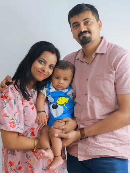 A lovely standing portrait that shows the connection between the parents as they hold their child together. It's a simple, beautiful composition.