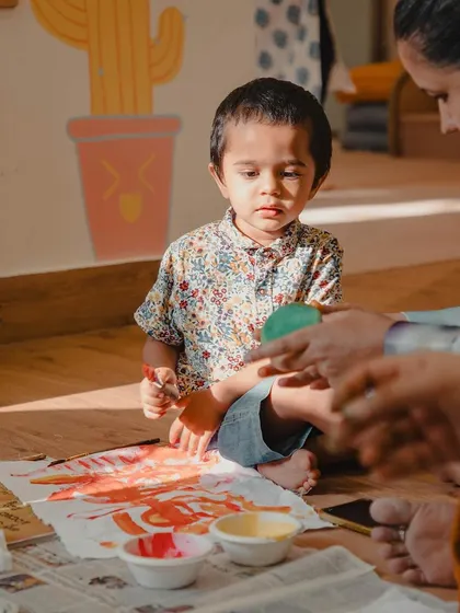 A young child explores colors and textures with paint. This image perfectly represents our philosophy of learning through messy, sensory play.