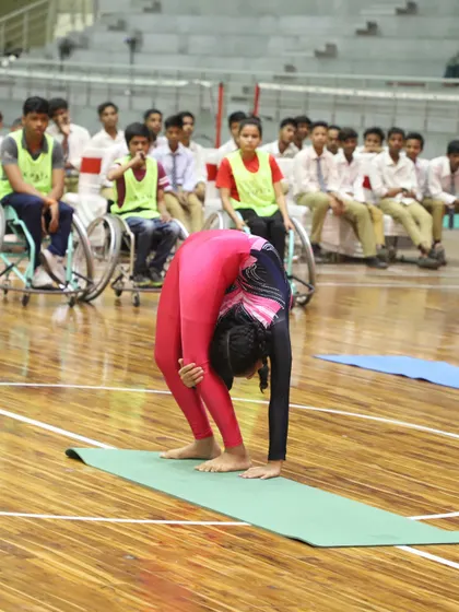 A young gymnast performs an incredible feat of flexibility during our National Sports Day celebration. The event also honored wheelchair basketball medalists, showcasing our commitment to inclusive sports.