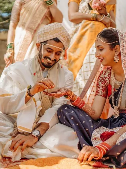A candid moment from a Kannada wedding ceremony, with the couple engaged in a traditional ritual.
