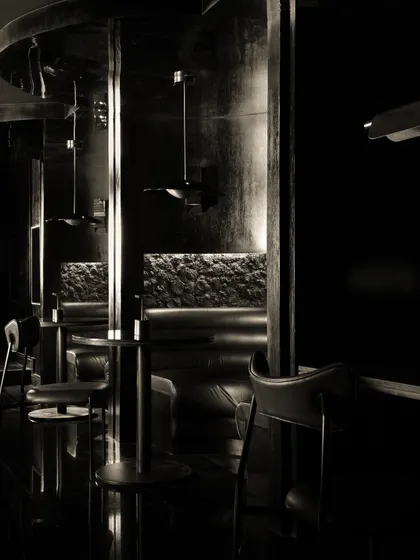 Details of the seating at Lair, where rough, rock-like textures meet smooth leather upholstery. This tactile contrast is central to the bar's sensory narrative.