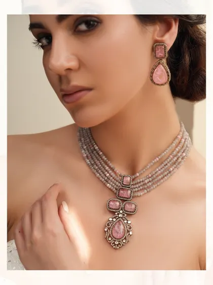 A beautiful necklace for a destination wedding, featuring a pendant with large pink stones on a string of grey beads.