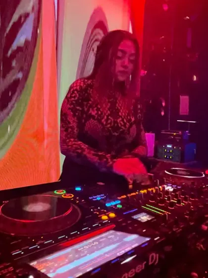A focused shot of me at the decks, surrounded by red and orange club lights.
