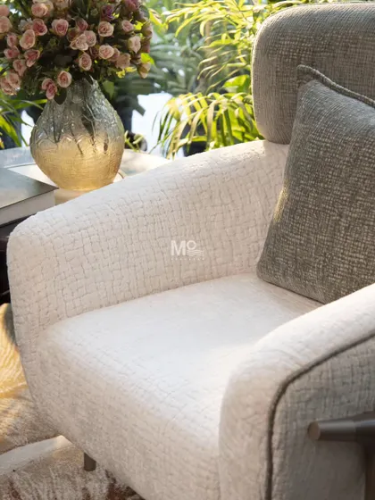 A close-up on the soft, textured bouclé fabric of the Verdelle Armchair. This view captures the tactile, grounding, and inherently warm feel of the material, which mimics the organic flow of nature.