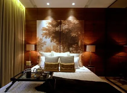 This bedroom from our Bellevue Apartment project exudes a warm, tropical vibe. The wooden wall paneling and nature-inspired artwork behind the bed create a cozy and inviting retreat.