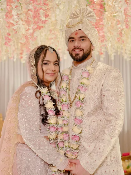 The couple at their ceremony. Madhura's baby pink lehenga and elegant makeup make for a stunning and modern bridal look.