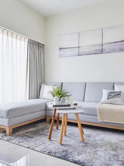 This living room from our 'Nordic Nest' project is a tranquil sanctuary defined by Scandinavian design principles. The light grey sofa, sheer curtains, and natural wood accents come together to create a bright, airy, and calming atmosphere.