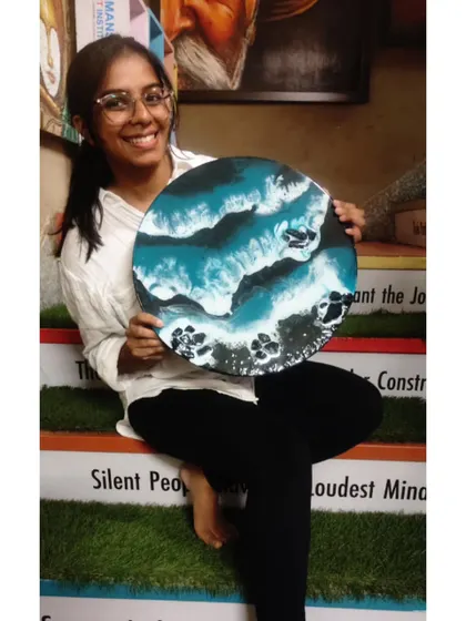 A student sitting on our institute's steps with her stunning ocean-themed resin art. We celebrate every creation and the artist behind it.