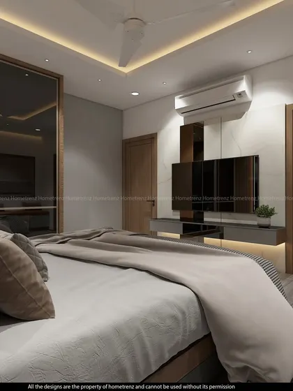 A view पुलिस the bed, showing the TV unit and the mirrored wardrobe that reflects the space.
