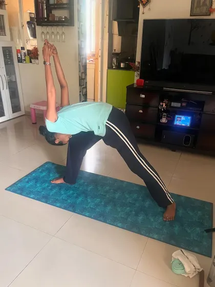 A client performs a humble warrior pose, a deep forward bend and hip opener that also challenges balance.