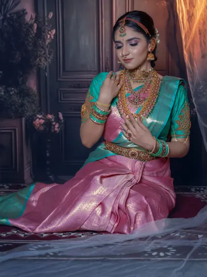 A seated pose showing the beautiful drape of the silk saree and the intricate layers of our temple jewellery.