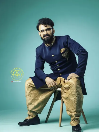 My men's collection includes classic Jodhpuri suits like this navy blue one with intricate embroidery on the collar and pocket square. It's a great rental for a sophisticated look.