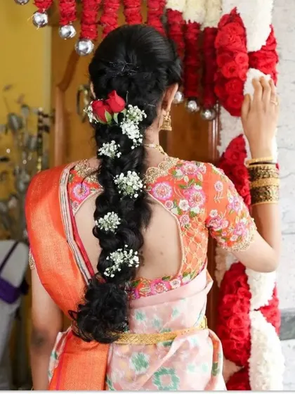 A bride's beautiful floral braid, perfectly complementing the floral embroidery on her blouse.