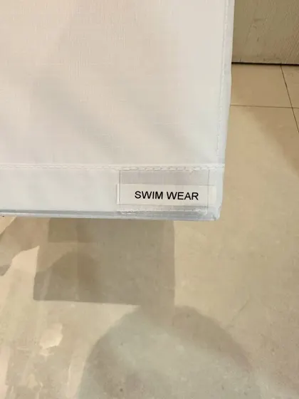 The final touch: a simple "SWIM WEAR" label. Labeling is key to ensuring everyone in the house knows where things belong, making it easy to maintain the system.