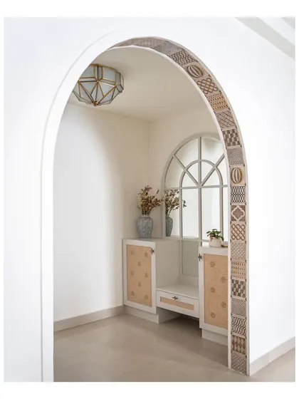The grand arch at the entrance of the home, covered with charming patterned tiles. This newly built arch cleverly separates the foyer while providing a welcoming glimpse into the living room.