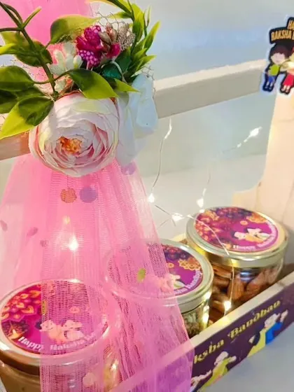 A close-up of the pink-themed wooden basket hamper, showing the fairy lights and custom-labeled jars.