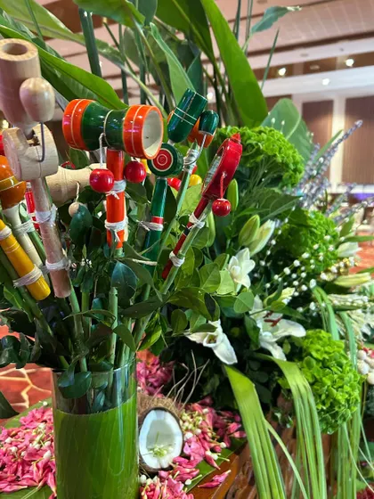 A detailed view of the handcrafted wooden toys nestled amongst fresh white lilies and lush greenery.