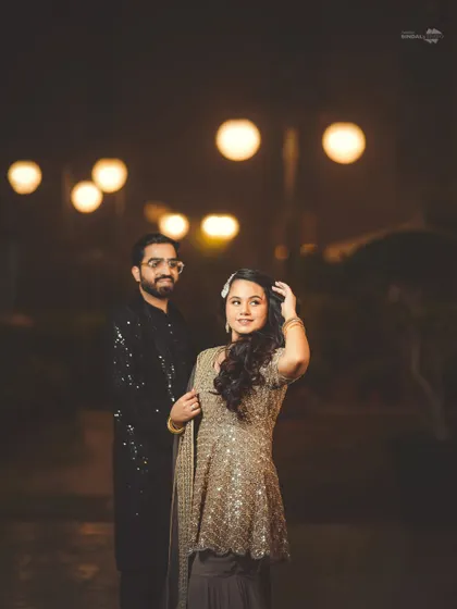 A stylish outdoor portrait of the couple at night. The bokeh effect from the lights in the background adds a magical and romantic touch to the photograph.