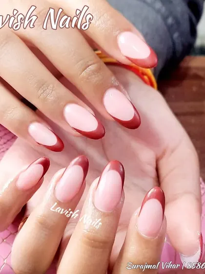 A bold and elegant French manicure with a rich maroon tip on almond-shaped nails, perfect for matching a bridal lehenga.