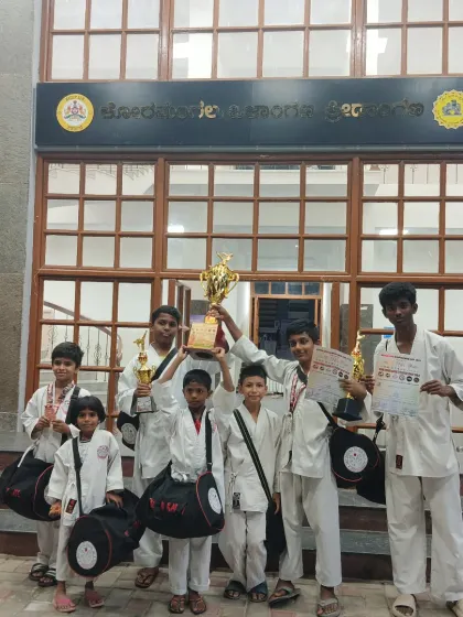 Our team celebrating their victory at the 4th Bengaluru Kempegowda Cup 2025, holding their trophies high outside the venue.