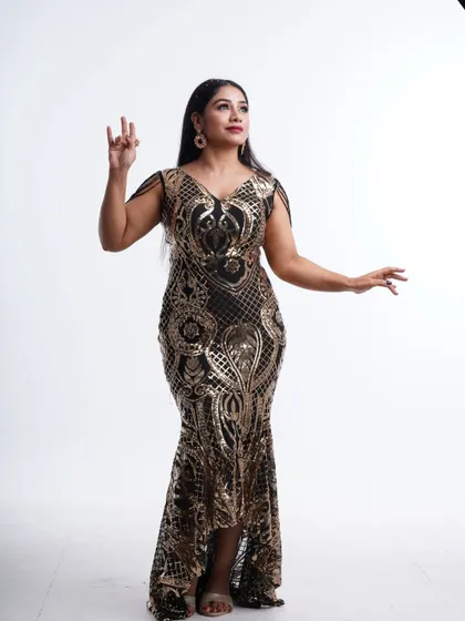 A full-length view of the black and gold sequin gown, showcasing its elegant mermaid silhouette and sparkling details.